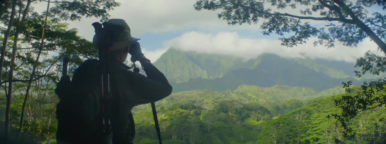 Man looking at mountains through binoculars