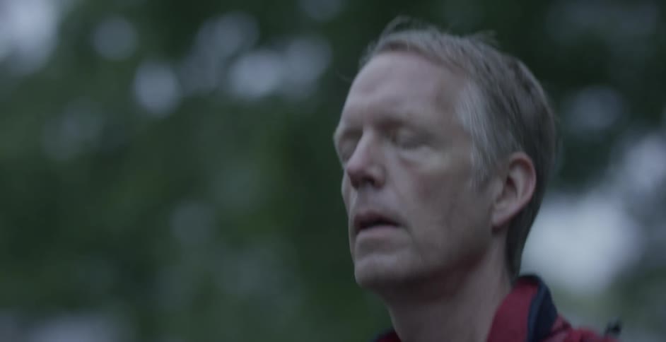 A man jogs past trees