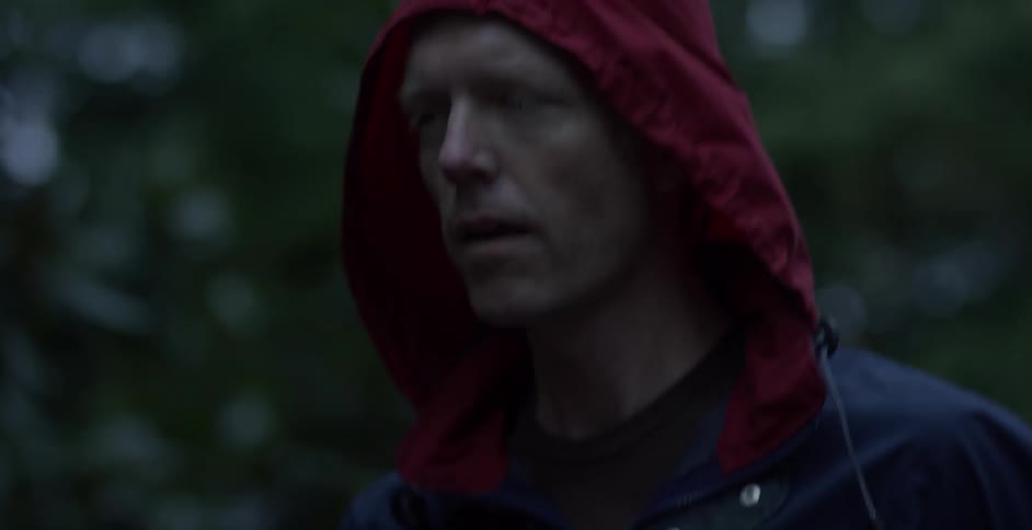 A man is running outside wearing a hood