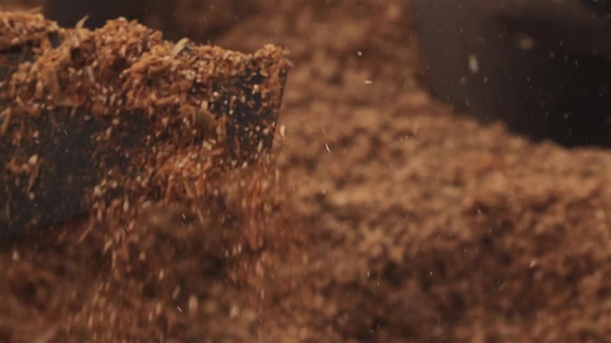 Organic matter is churned in a machine with heavy blades