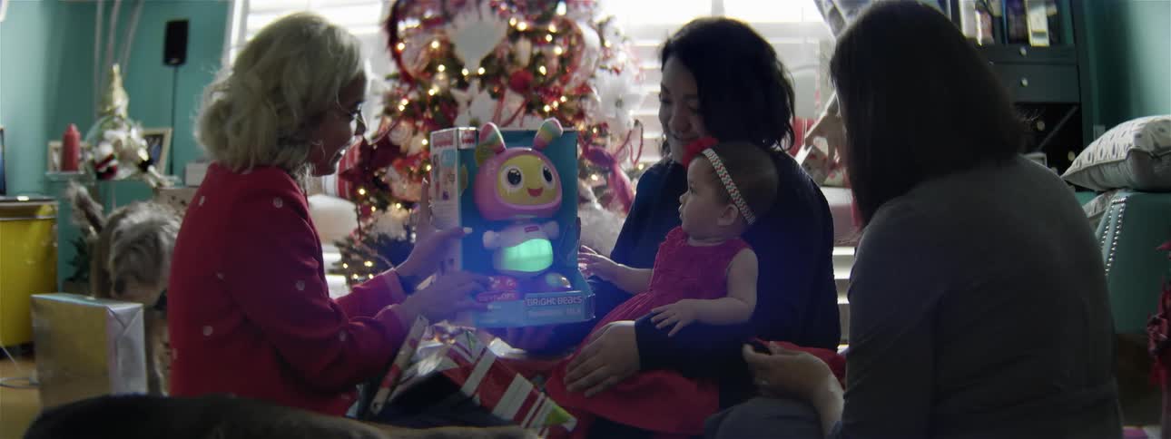 An older woman is showing a toy to a baby at christmas