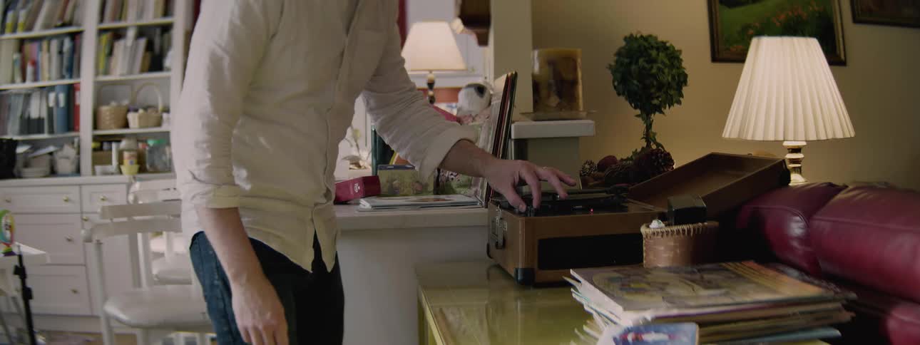 A man places a record on a record player