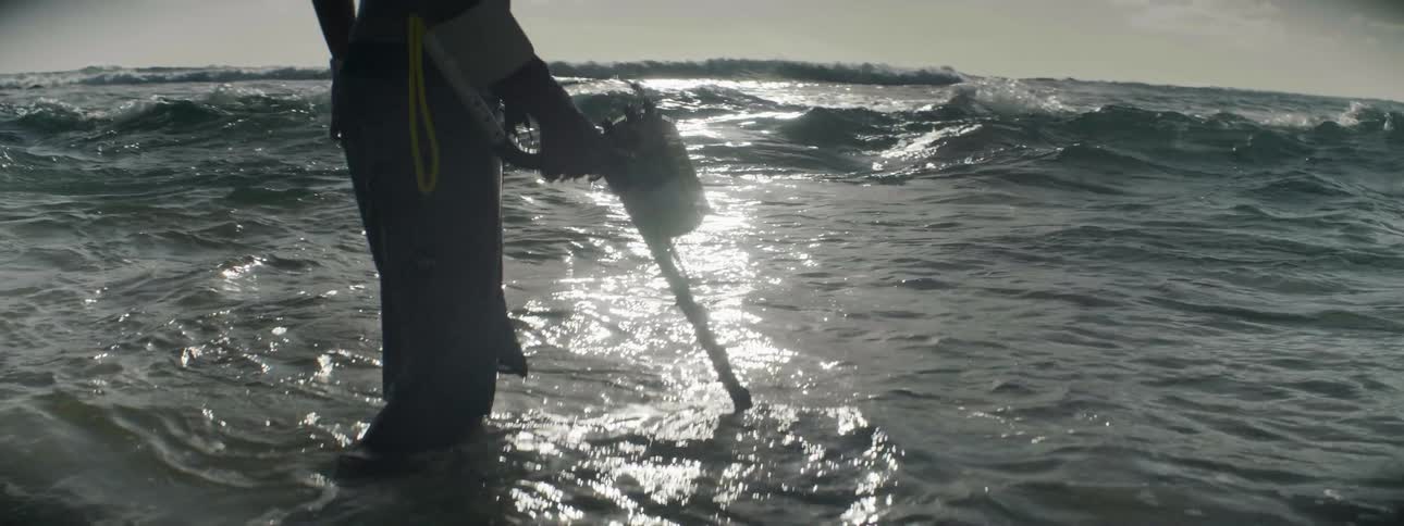 A man is searching for treasure with a metal detector