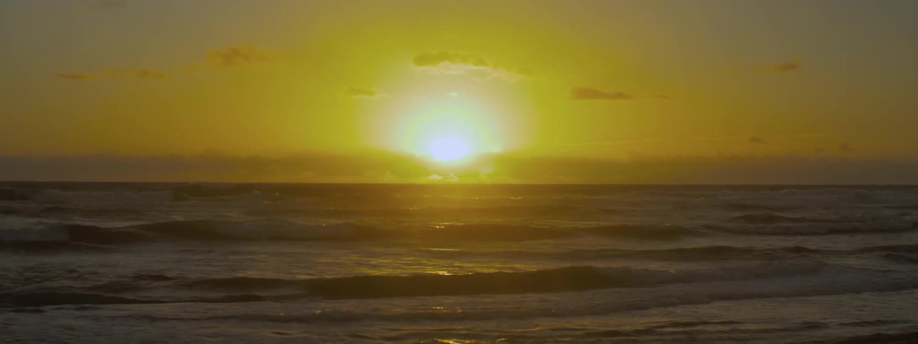 The sun rises over ocean waves