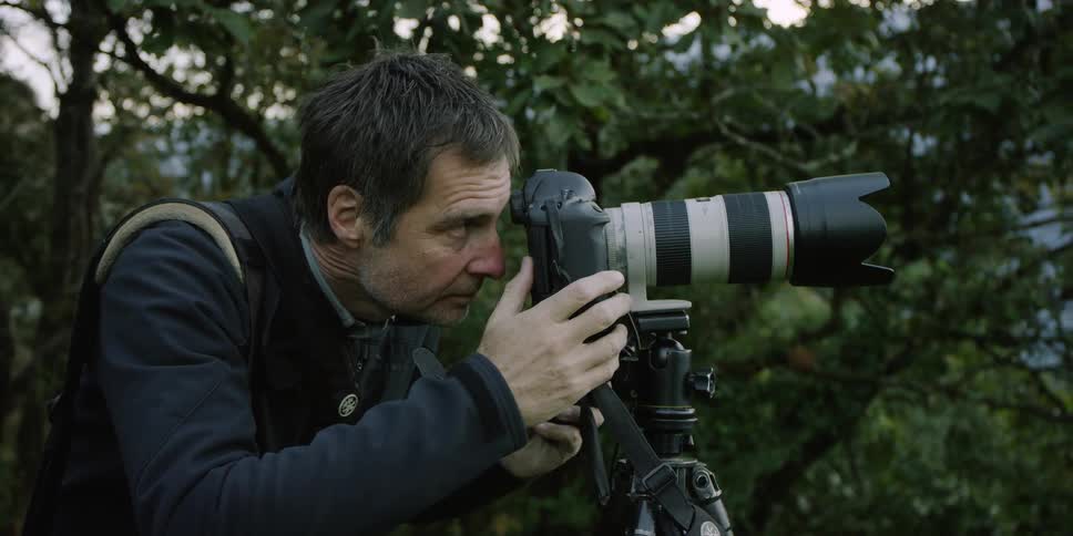 A man adjusts a camera