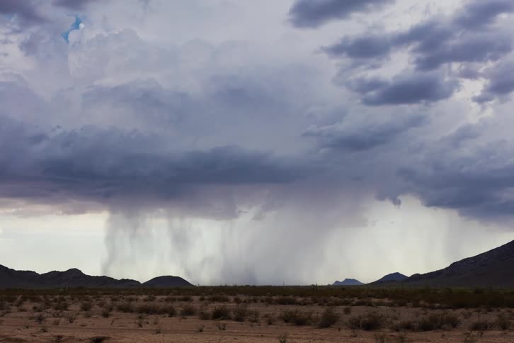 Rain clouds moving over hilly plains