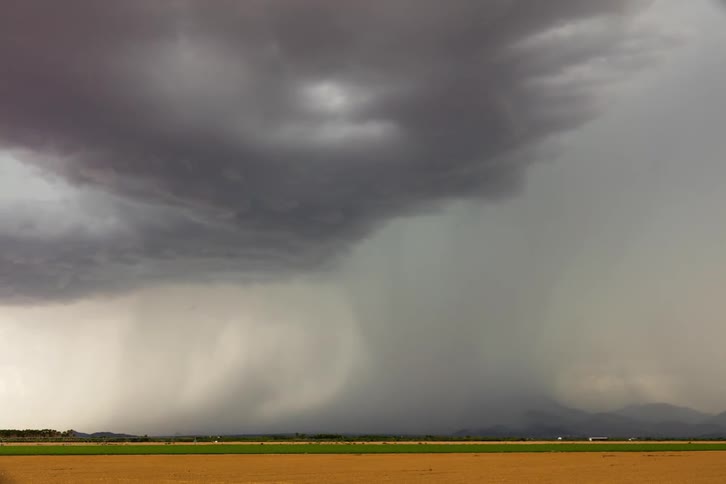 Rain clouds rolling over plains and lightning strikes