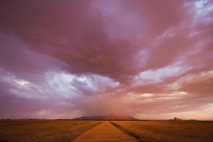 Rain clouds moving over plains with the sun partly shining