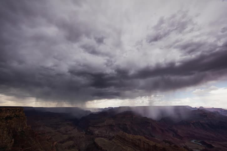 Rain clouds gather and move over rocky peaks