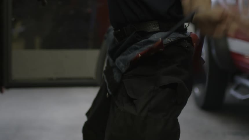 Man pulling overalls up over clothes