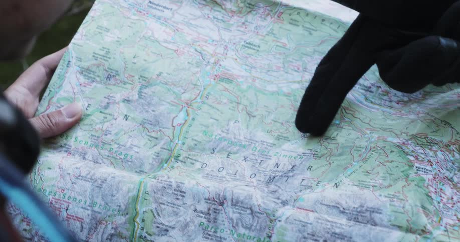 A person holds a map while another person points out a path