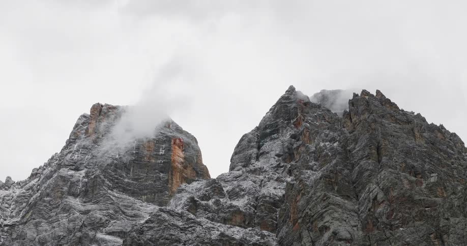 Clouds billowing over rocky mountain tops