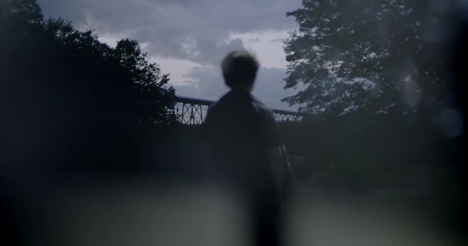Silhouette of a child standing outside at sunset