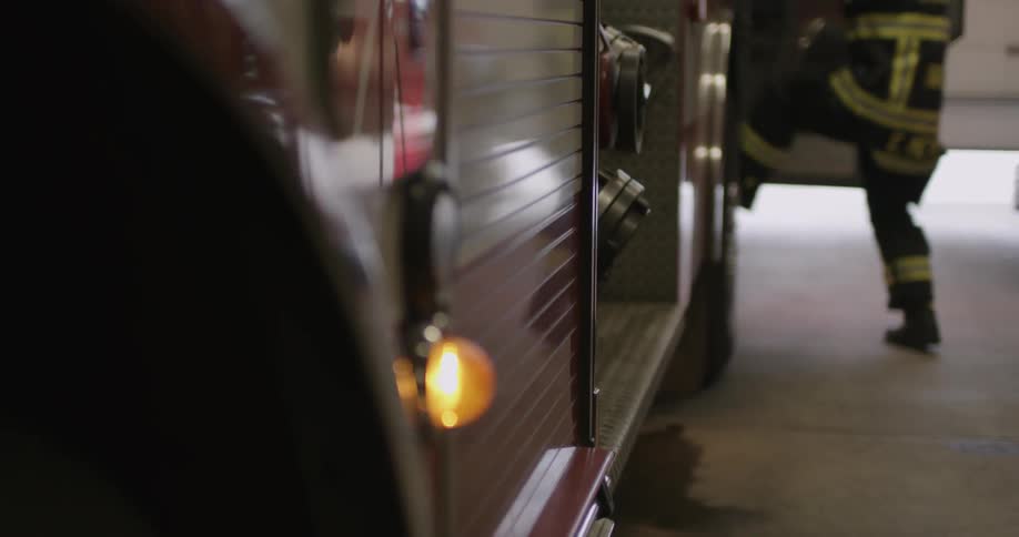 A firefighter enters a firetruck