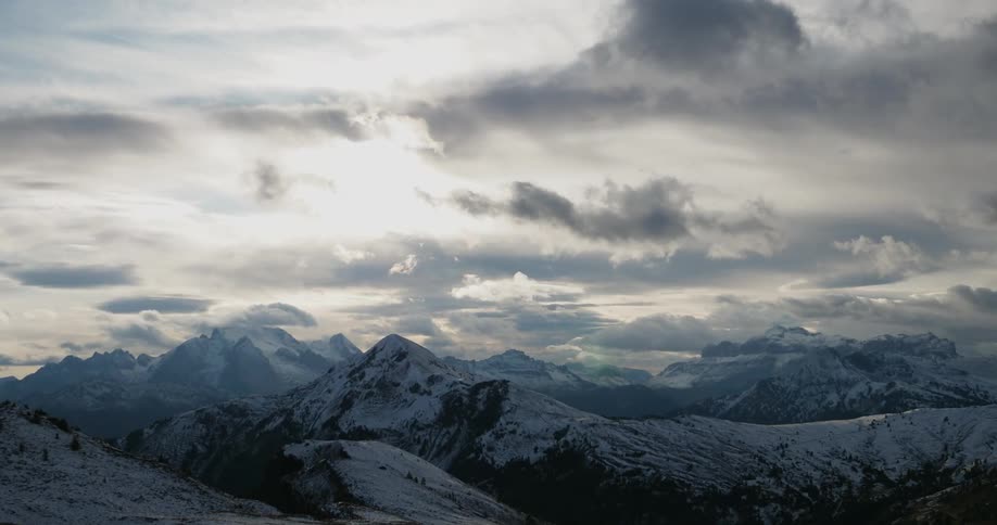 Clouds rolling over snowy mountains