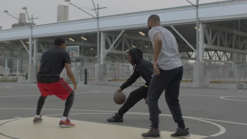 Group of men playing basketball in the city