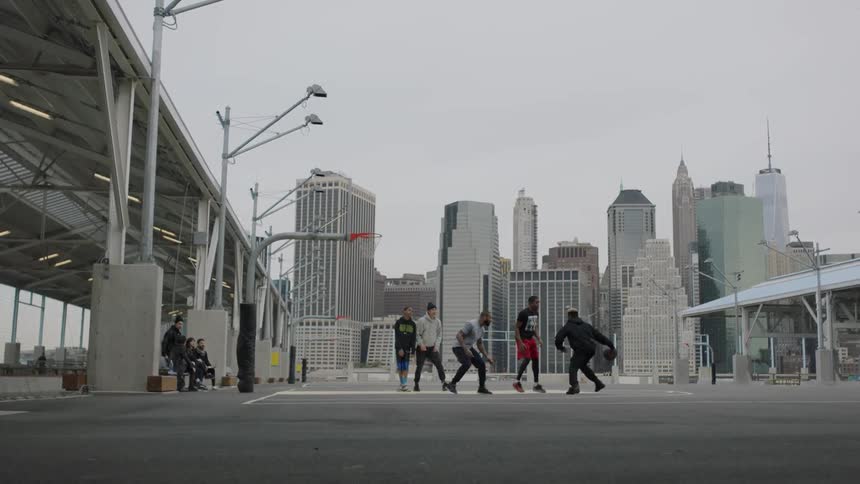 Young men play basketball outside in the city
