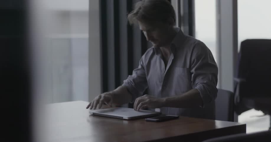 A man walks through a modern glass office building