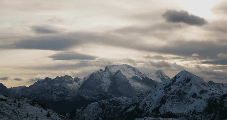 Clouds rolling over snowy mountains