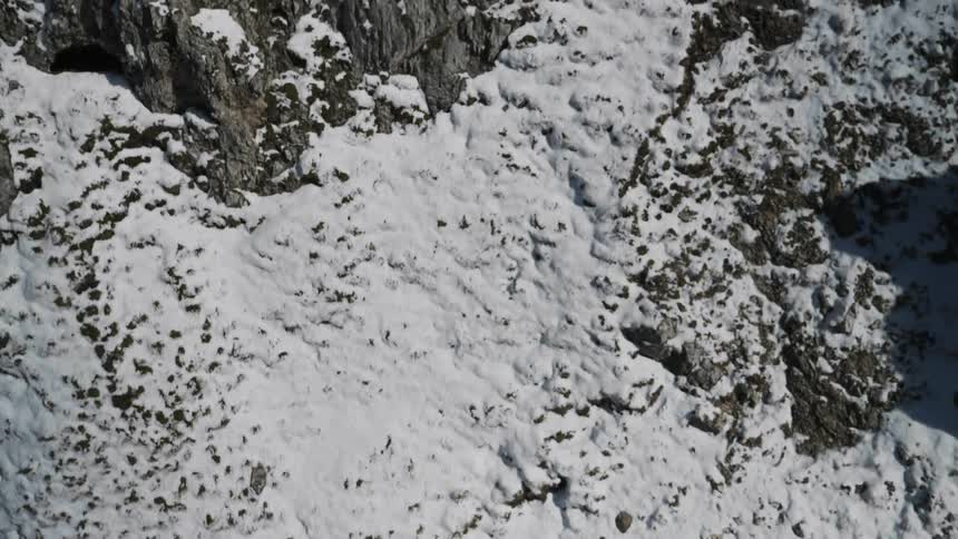 Large rocky area covered in snow and dirt
