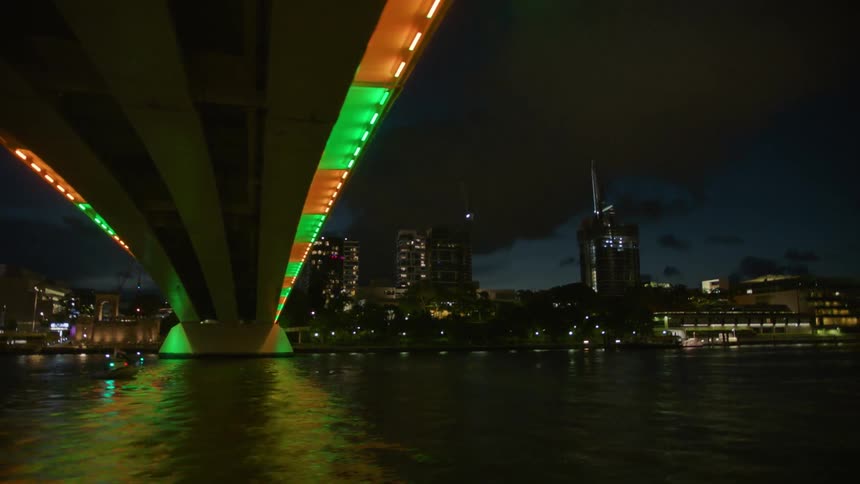A bridge with alternating green and orange lights