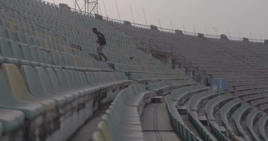 A man running up stadium stairs
