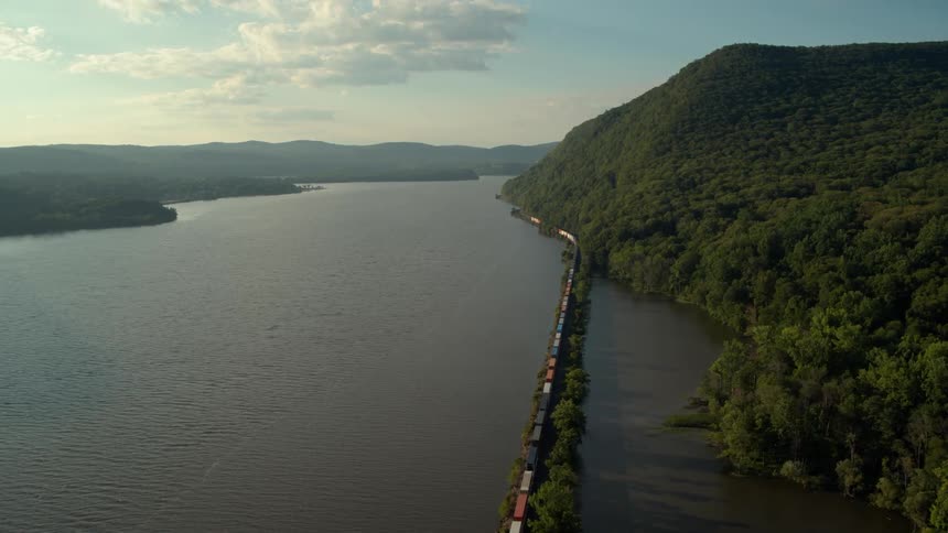 Train traveling alongside a large river