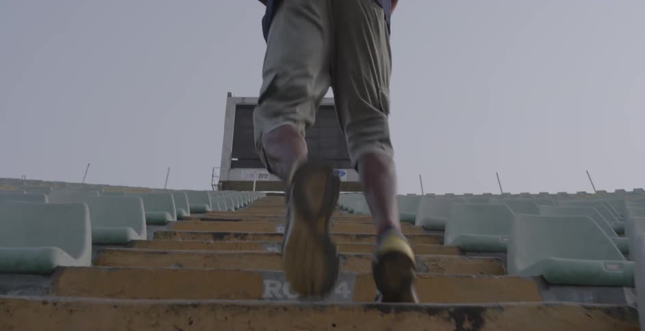 A person running up some steps outside in a stadium