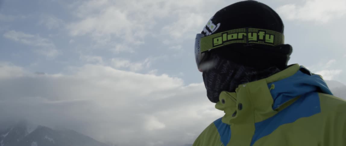 Man wearing goggles standing on a mountain top