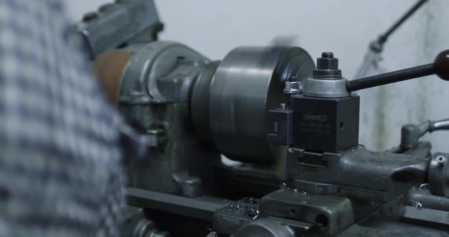 Person turns a crank on a machine so it spins