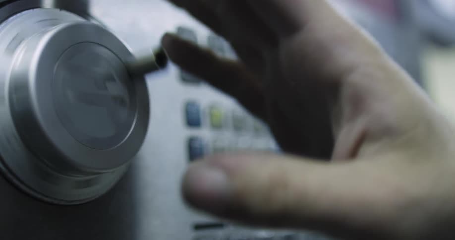 A person spins a dial on a machine