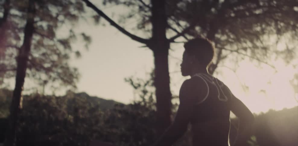 A female athlete is walking on a path in a natural setting at dusk