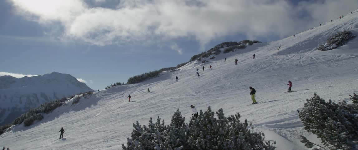 Many people skiing down a large mountain