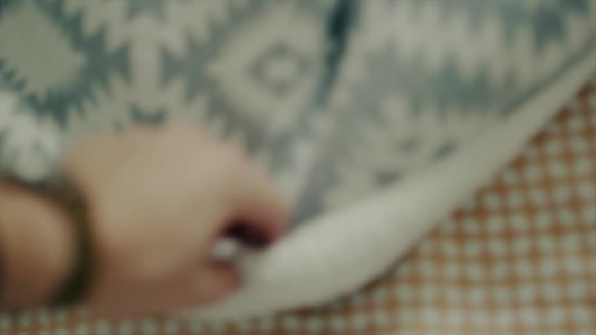 A woman covers a baby's feet with a blanket