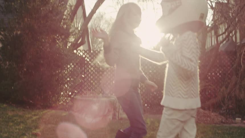 Two girls are playing in a backyard during the day