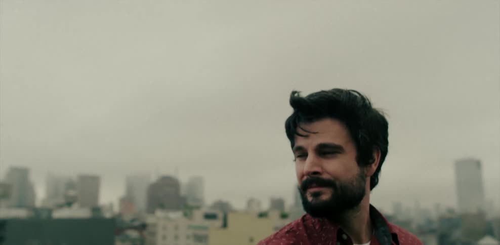 Man standing on a rooftop looking down