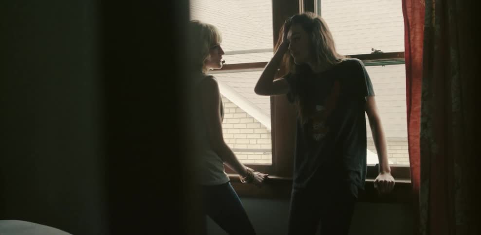 Two women talk by the window