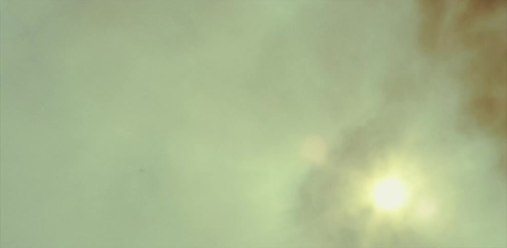 Smoke billowing and the sun shining