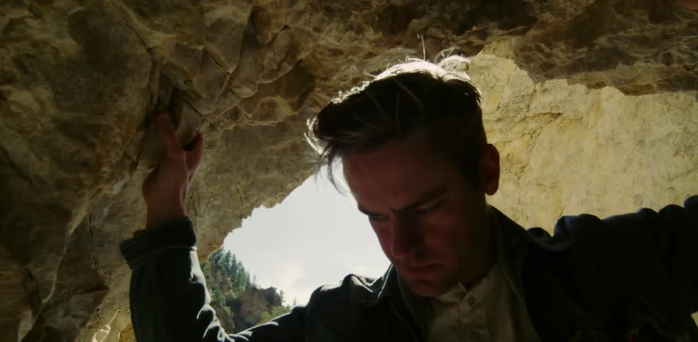 Man standing in a cave on a sunny day