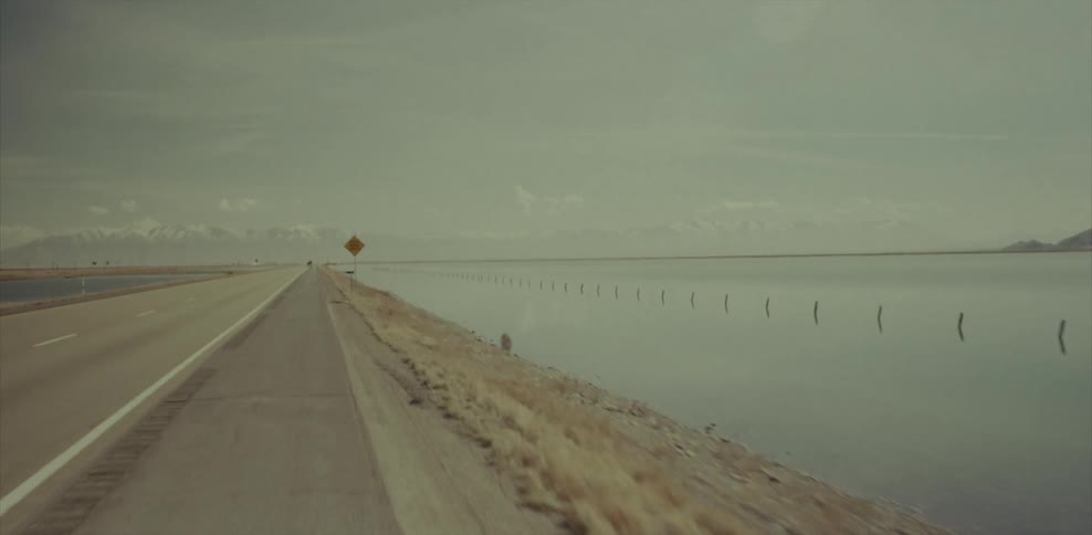 Roadway stretching along a long waterline on a cloudy day