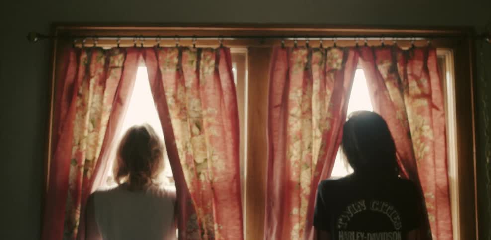 Two women look out separate windows