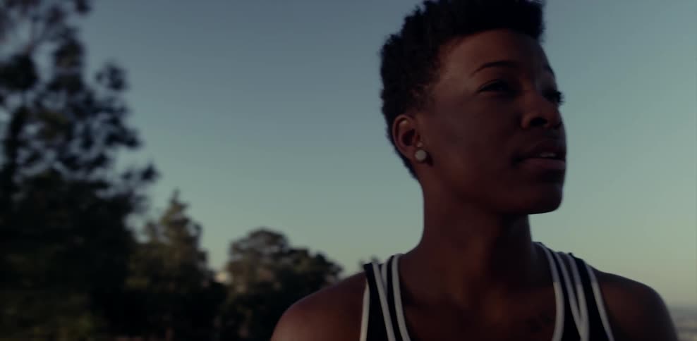 A woman smiles and talks to herself as she stand taking in her surroundings at dusk