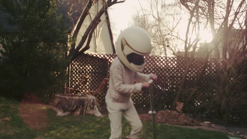 A child rides a scooter wearing a helmet