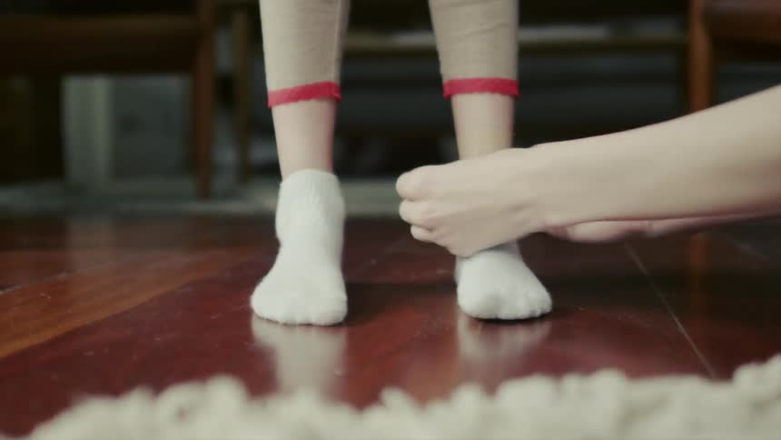 A woman puts a band-aid on a child's leg