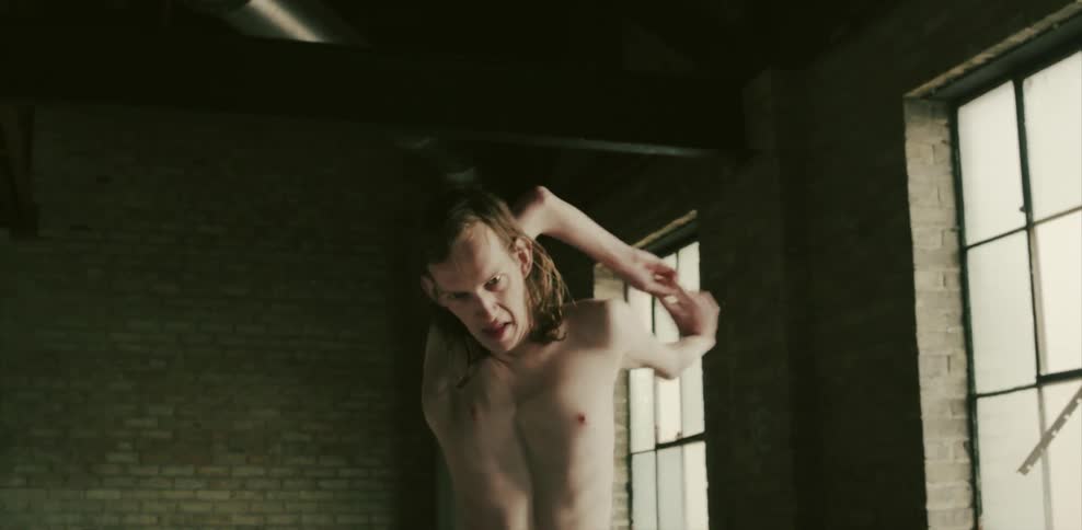 A double jointed man rotates his shoulders around his head