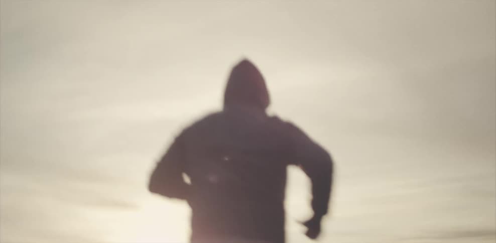 Person running across sandy landscape on a sunny day