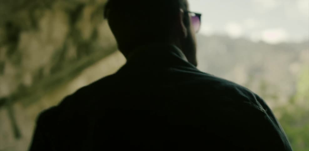 Man walking through a cave out into the sunlight