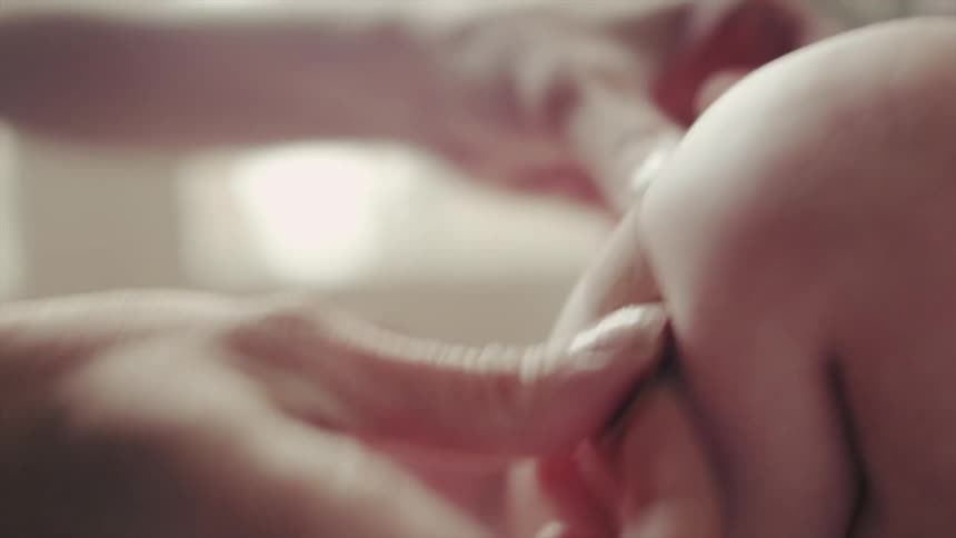 A woman puts a bandage onto a baby's kicking legs