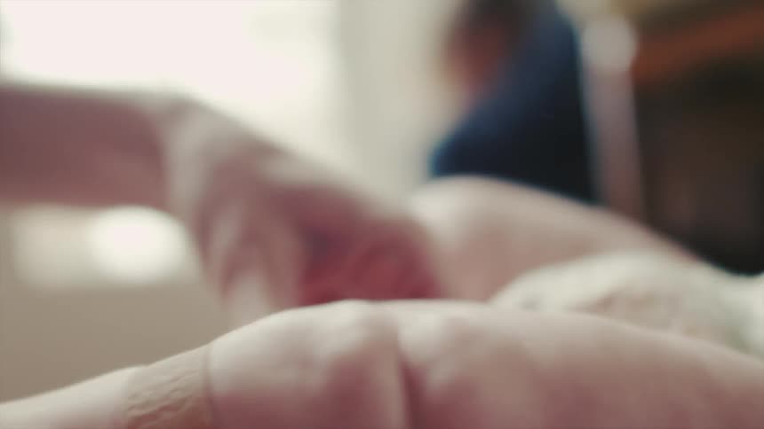 A woman puts a bandaid on a diapered baby's leg