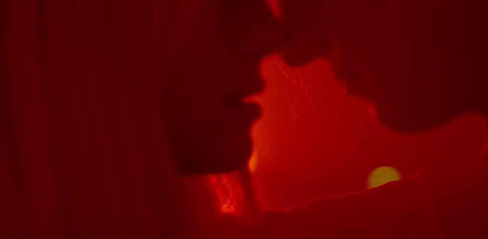 Man and woman hug and kiss in red light